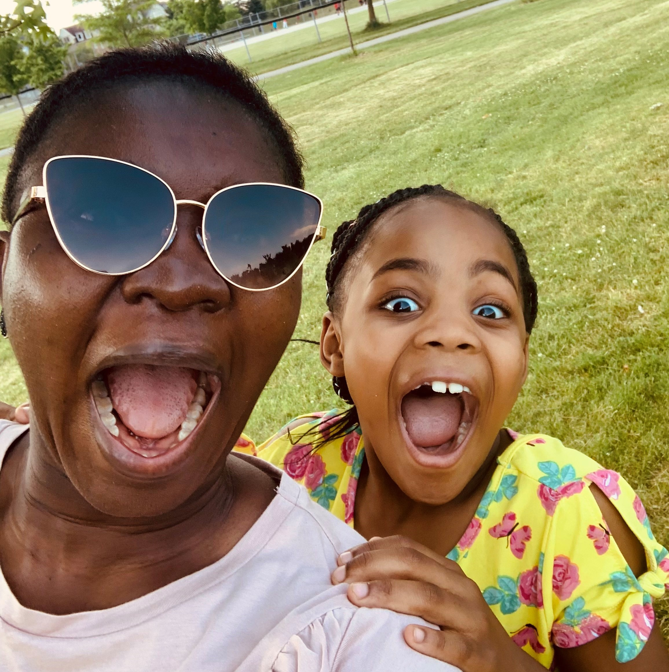 Picture of a black woman mentor with her mentee. Both are making goofy faces.