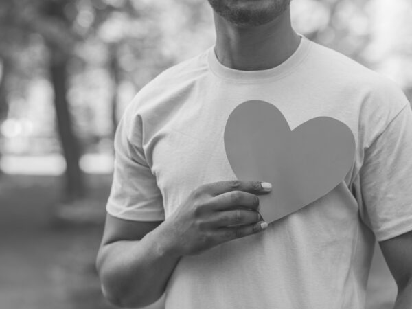 black and white photograph of man holding a heart